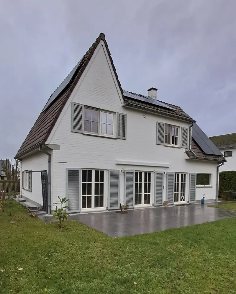 Maison blanche équipée de panneaux solaires par BilElectricité